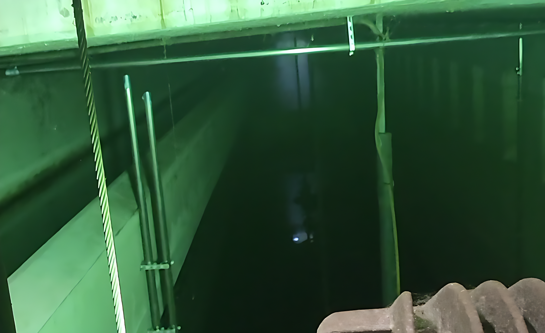Innenaufnahme des SEM Regenrückhaltebeckens mit Wasser und technischer Infrastruktur zur Regenrückhaltung und Abflusssteuerung.