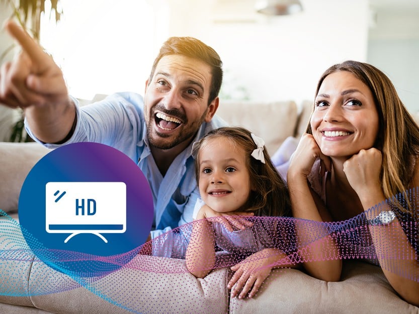Eine begeisterte Familie sitzt zusammen auf der Couch und schaut Fernsehen. Eine überlagerte Grafik mit einem TV-Bildschirm, dem Schriftzug HD und leuchtenden Datenwellen symbolisiert die brillante Bildqualität von medl Glasfaser-TV.