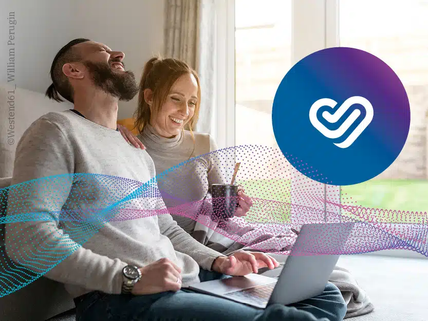 Lachendes Paar am Laptop mit gigaverliebt-Logo und grafischen Wellen für stabiles Glasfaser-Internet.