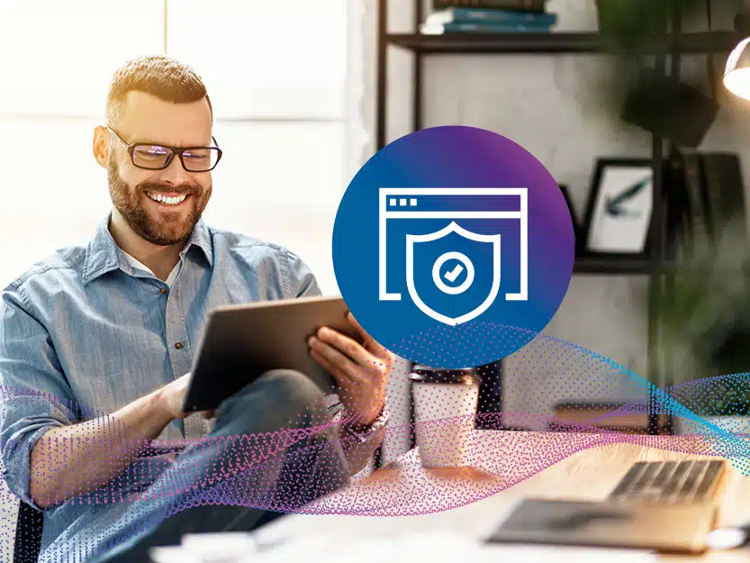 Lächelnder Mann mit Tablet im Homeoffice, Schild-Icon symbolisiert Zukunftssicherheit des medl Glasfasernetzes in Mülheim.