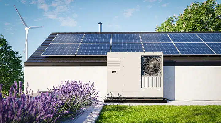 Ein modernes Einfamilienhaus mit Photovoltaikanlage, Wärmepumpe und Windrad im Hintergrund – medl bietet die Infrastruktur für eine effiziente Kombination.
