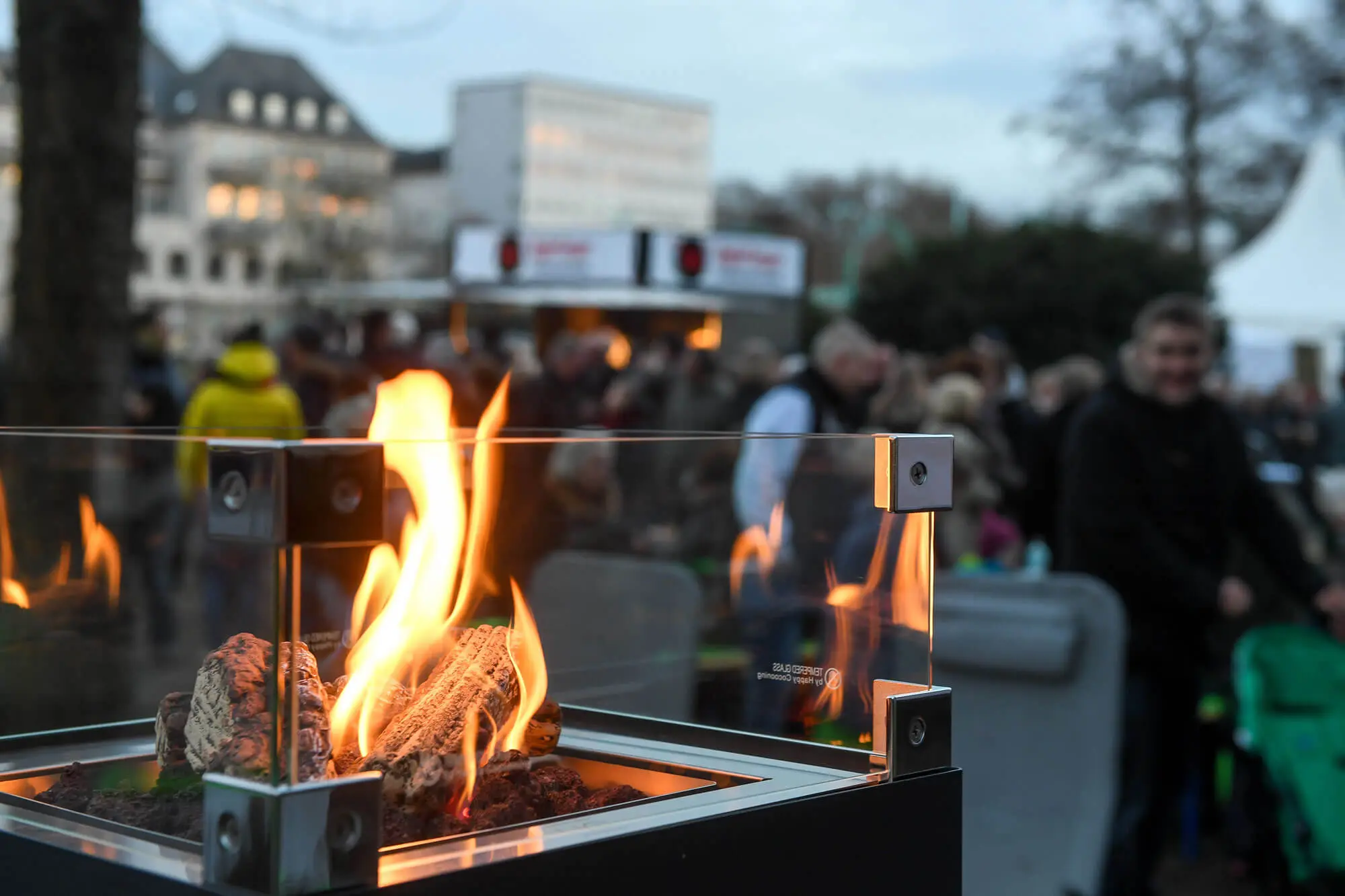 Blick auf Menschen beim medl-Winter-Grillen mit Gasgrill im Vordergrund