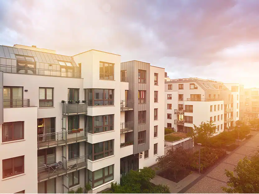 Luftbild von einer Wohnanlage mit mehreren Mehrfamilienhäusern – Symbol für die Wertsteigerung durch Lademöglichkeiten für Wohnungseigentümer